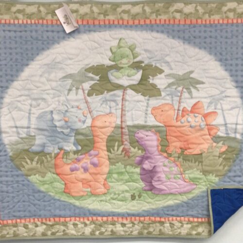 Baby Dinosaur panel quilt featuring a newly-hatched dinosaur in a tree surrounded by prehistoric friends.