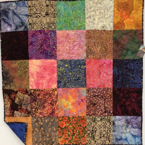 Square lap quilt featuring 25 large batik fabric squares in vibrant colors including blues, purples, pinks, oranges, and greens