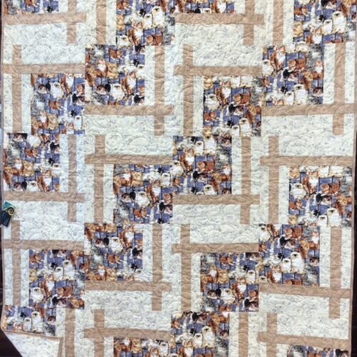 Cat Lover patchwork throw quilt in blue, tan, and off-white with a focal print of cats on a blue background.