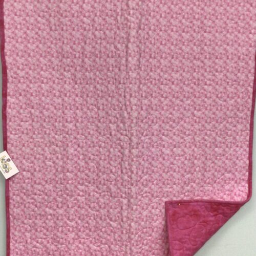 Soft pink flannel baby quilt with multicolored bubble print and darker pink binding and backing with butterfly quilting