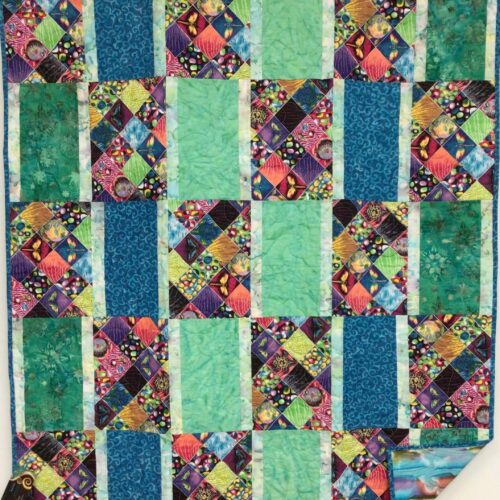 Children's Eye Spy quilt with rectangle blocks featuring colorful squares of fish, turtles, butterflies and other objects alternating with blue and green rectangles