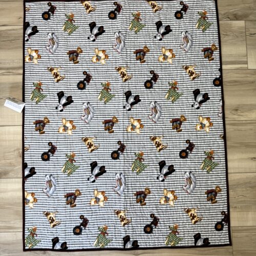 Baby quilt with toy teddy bears, farm animals, dogs, and pandas scattered across gray and white horizontal striped background