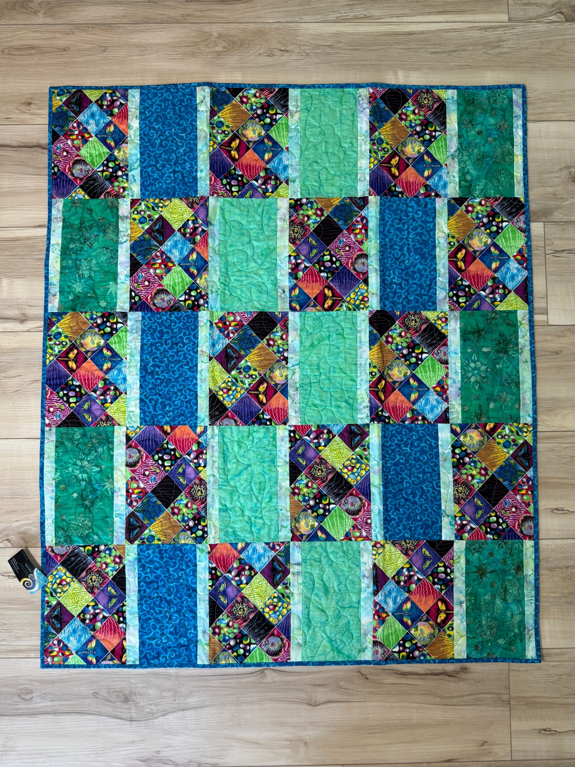 Children's Eye Spy quilt with rectangle blocks featuring colorful squares of fish, turtles, butterflies and other objects alternating with blue and green rectangles