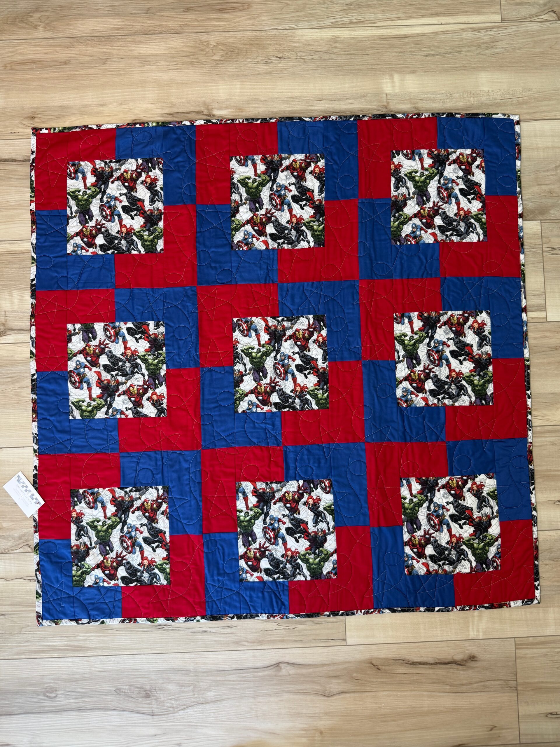 Avengers baby quilt featuring the iconic Marvel characters coordinated with bold red and blue tones on the front. The backing is a matching Avengers print.