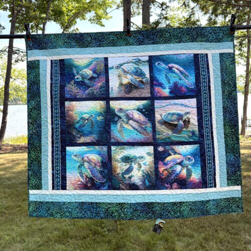 Lap quilt with nine sea turtle panels in iridescent colors, separated by black sashing with multiple borders