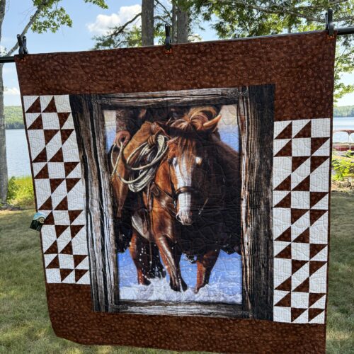 Lap quilt featuring working horse panel in browns with wood-grain border flanked by Double X blocks in cream and brown