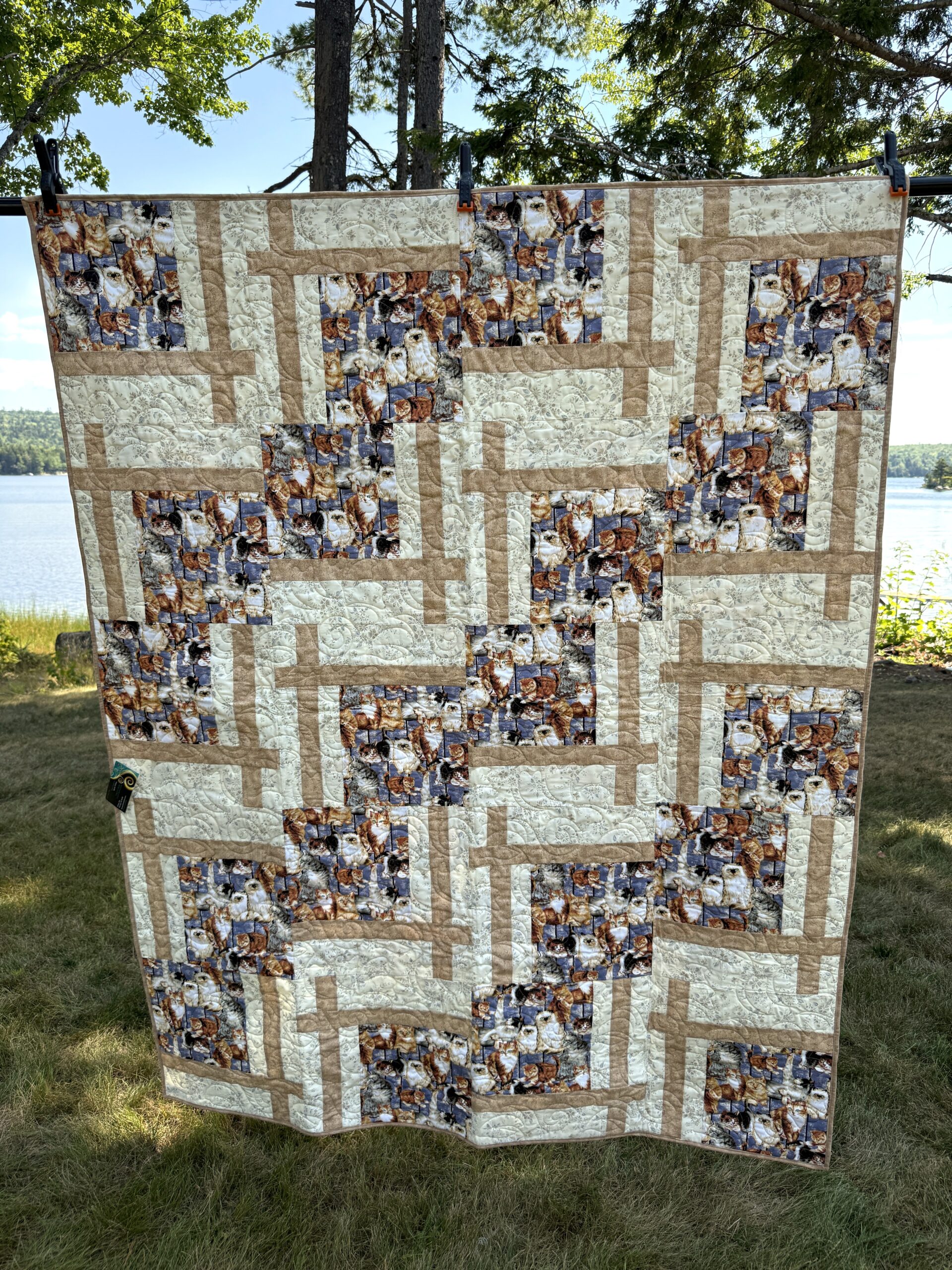 Cat Lover patchwork throw quilt in blue, tan, and off-white with a focal print of cats on a blue background.