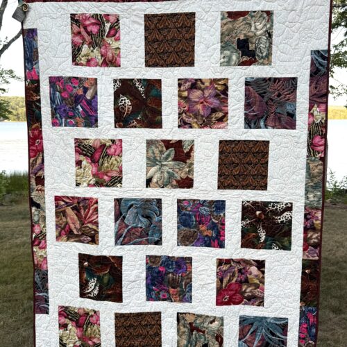 Modern Bold Florals quilt with large botanical squares set on a white background with a scrappy border and long-arm flower quilting.