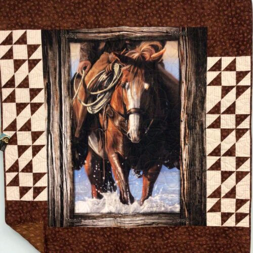 Lap quilt featuring working horse panel in browns with wood-grain border flanked by Double X blocks in cream and brown