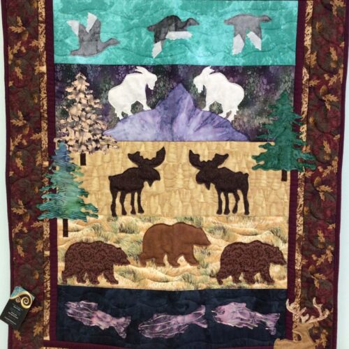 Wildlife wall hanging featuring four scenic panels with waterfowl, mountain goats, moose, bears, and fish in raw edge appliqué with burgundy oak leaf border