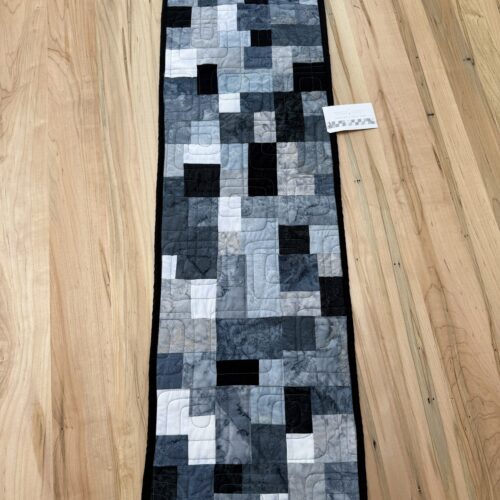Modern quilted table runner with blocks in gray, black, and white fabrics with Bauhaus geometric quilting