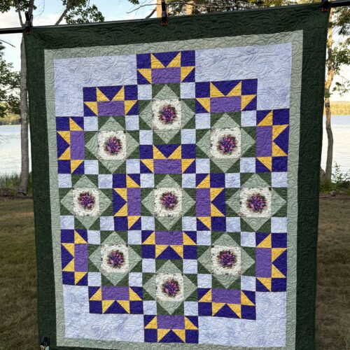 Throw quilt with circle of nine pansy bouquets in green, purple, and yellow