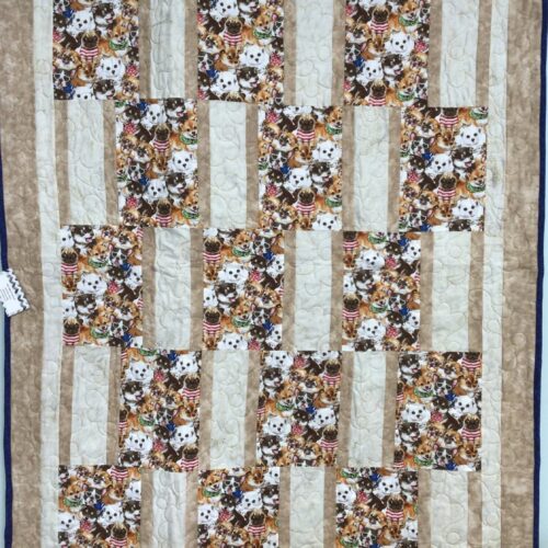 Handmade baby quilt with packed puppy print blocks in tan strip piecing, featuring playful dogs in costumes